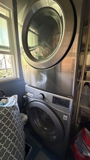 A compact washer and dryer unit with a window above the dryer.