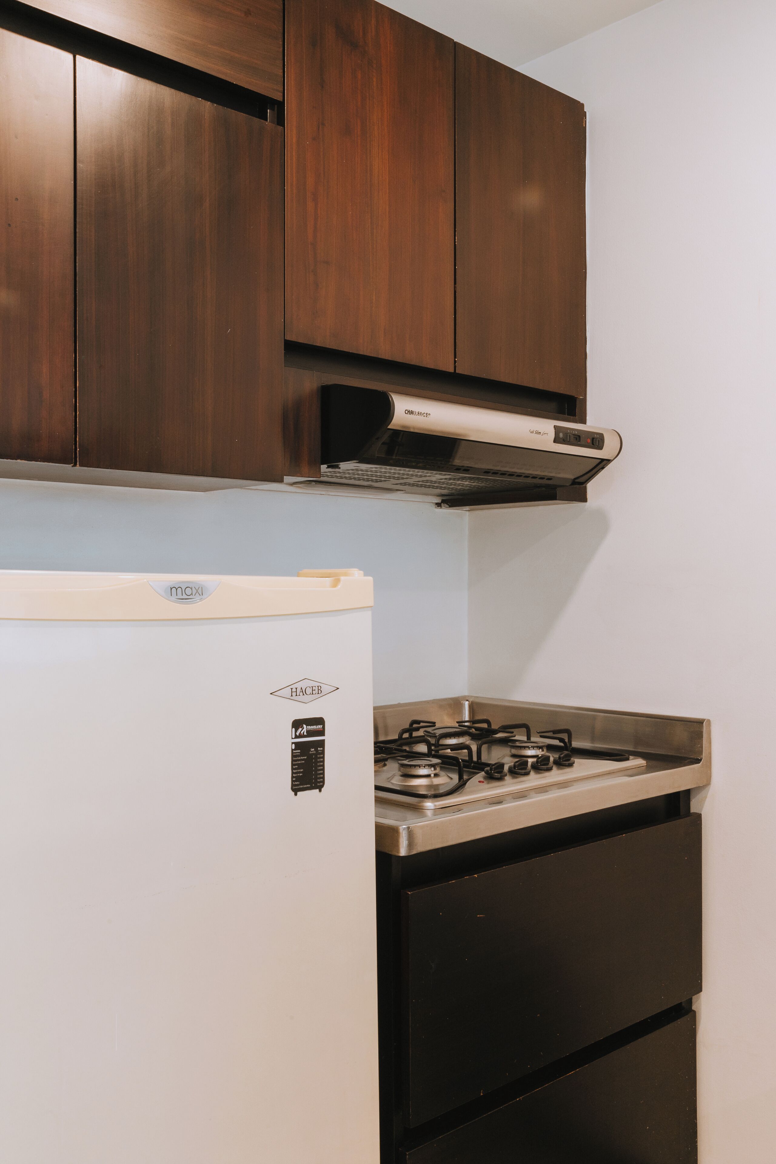 Una cocina con un refrigerador blanco, una estufa y armarios de madera.