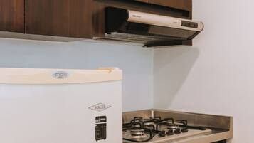 Una cocina con un refrigerador blanco, una estufa y armarios de madera.