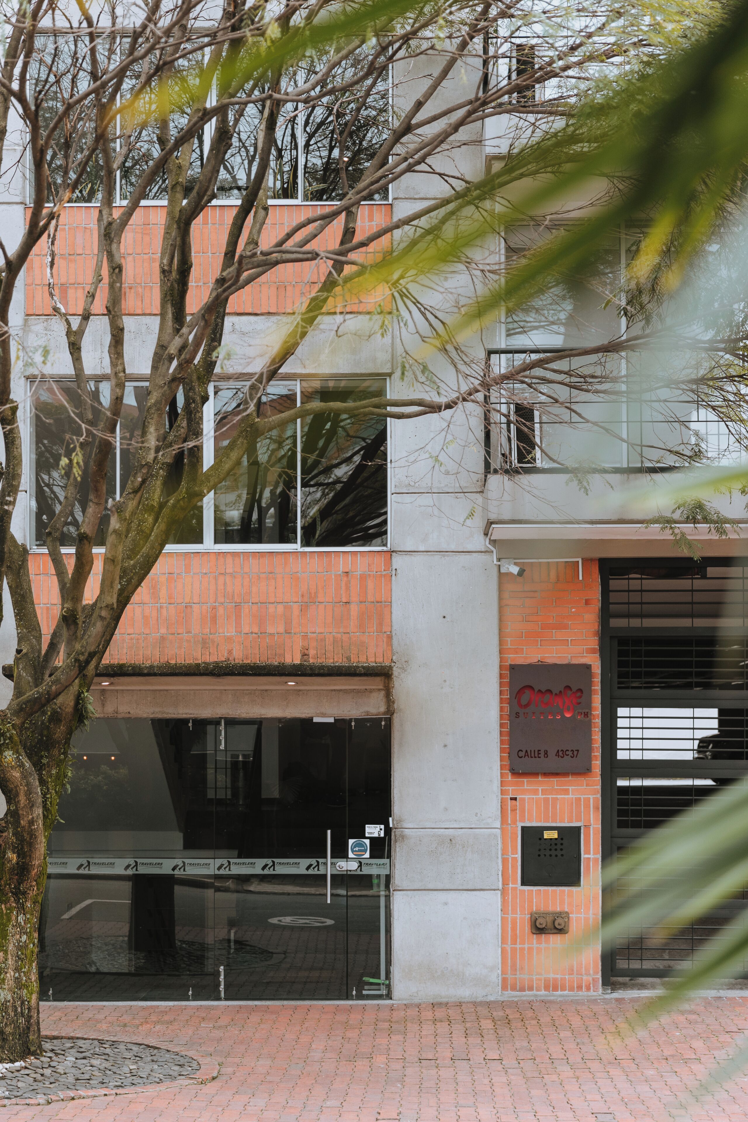 A building with a brick facade, a glass entrance, and a sign reading "Orange Studio."