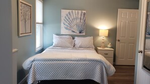 A bedroom with a bed, nightstand, and a door. -  Penthouse Suite in the heart Sylvan Beach Resort (Sylvan Beach)