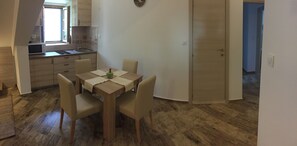 Una cocina compacta con una mesa, sillas y un microondas.