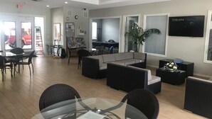 Un hall espacioso con una zona de estar, una mesa de comedor y un televisor montado en la pared.