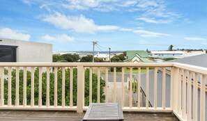 A balcony with a wooden floor and a metal railing.