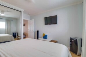 A hotel room with a large bed, a television mounted on the wall, and a minibar.