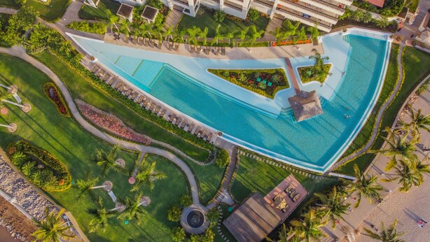 An aerial view of a resort with multiple swimming pools, palm trees, and a well-maintained landscape. - Molino de Agua BEST in PV, amazing location. best pool!  Walk EVERYWHERE (Puerto Vallarta)