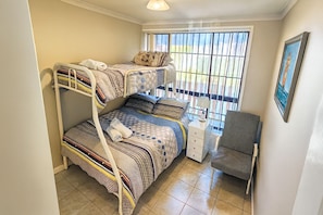 Une chambre de dortoir avec des lits superposés, un bureau et une chaise.