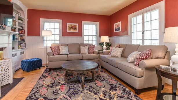 A living room with two sofas, a coffee table, and a bookshelf. - Gorgeous home: walk to beach, harbor, cliff walk, wiggly bridge, dining etc. (York Harbor)
