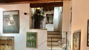 Un salon chaleureux avec un escalier, un coin repas et un autre escalier menant à l’étage supérieur.