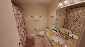 Un baño con inodoro, lavamanos y espejo.