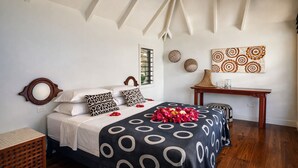 Quarto com cama, mesa de cabeceira, espelho, janela e parede decorada.