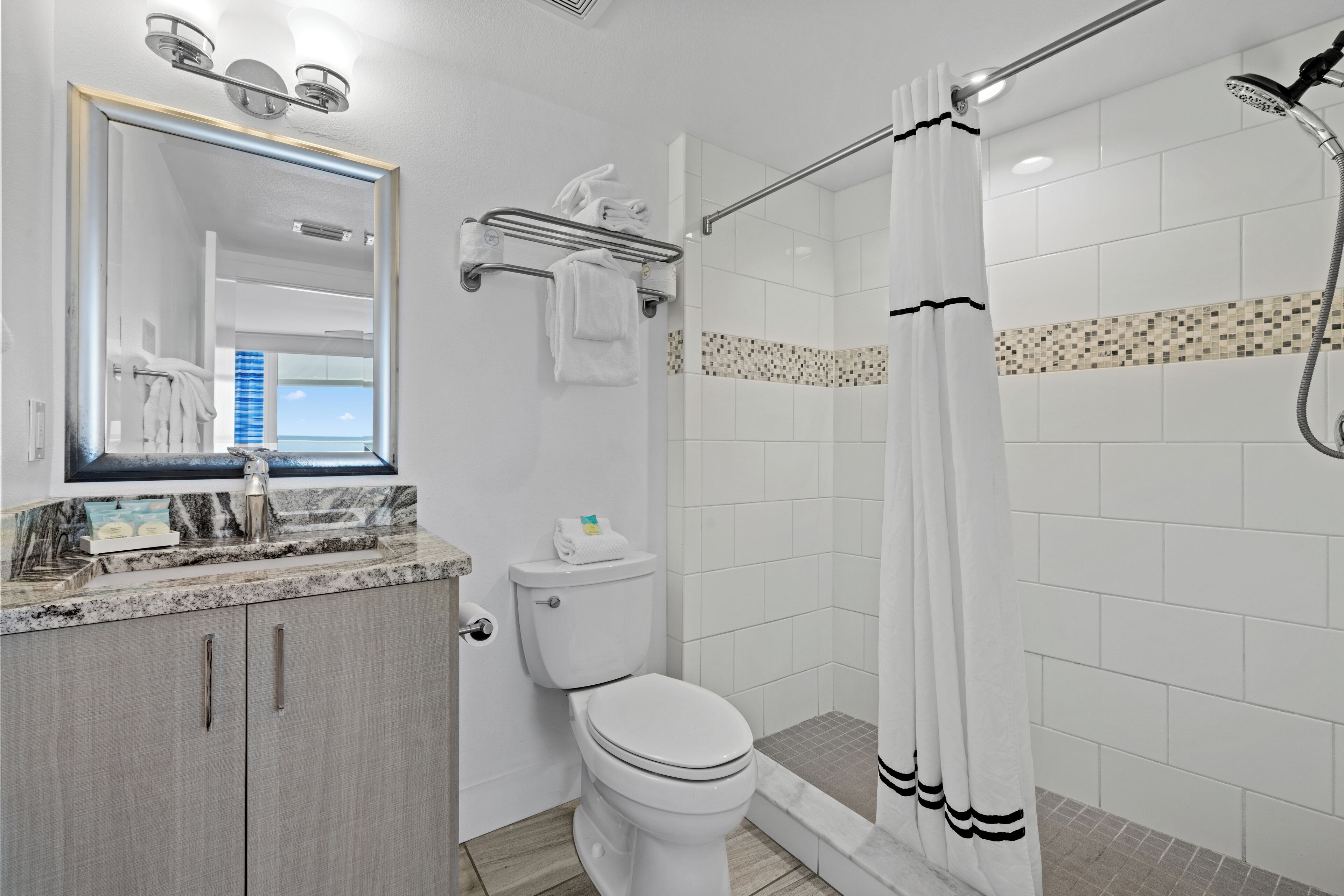 Une salle de bain avec des toilettes, un lavabo et une douche.