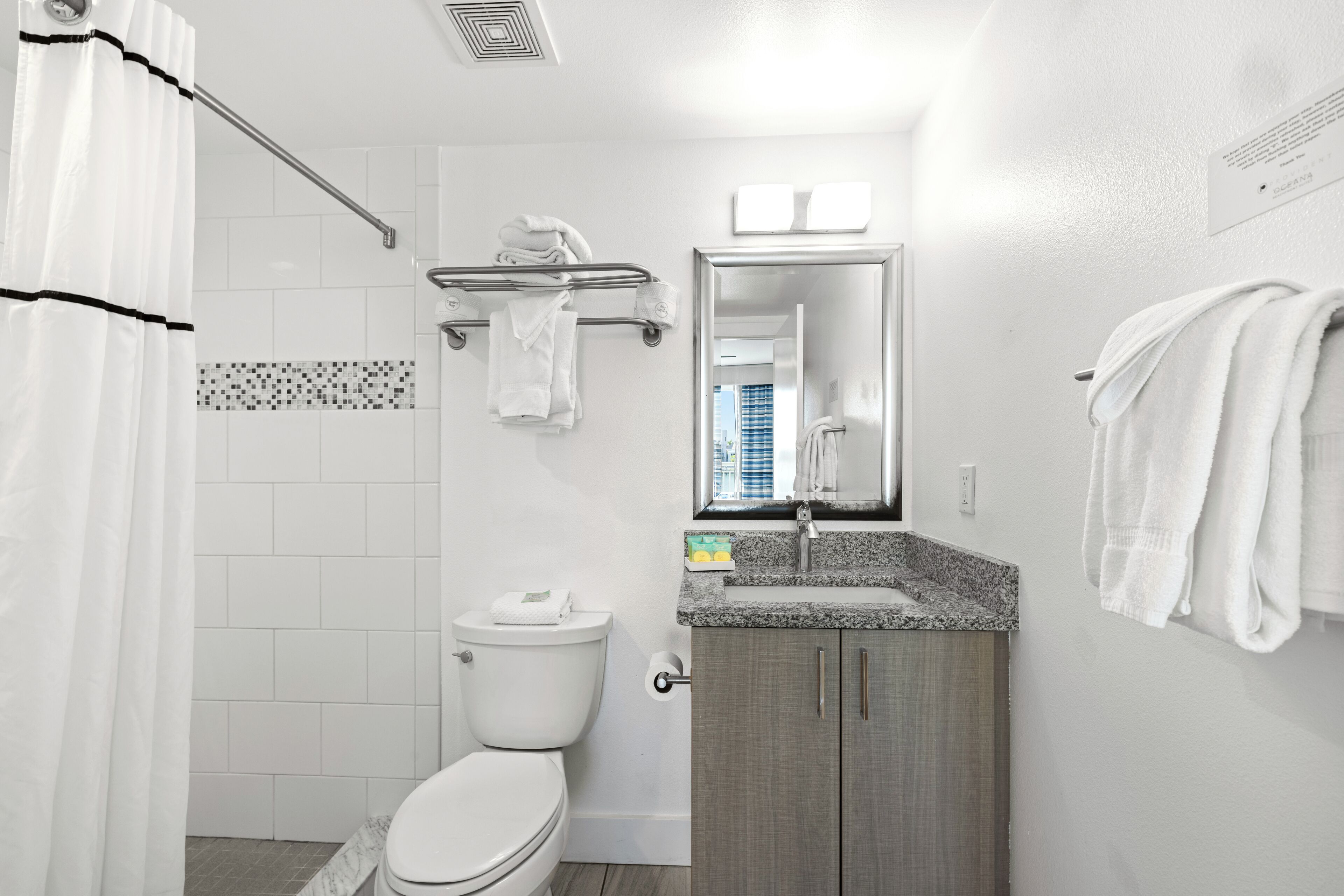 A modern bathroom with a toilet, sink, and shower area.