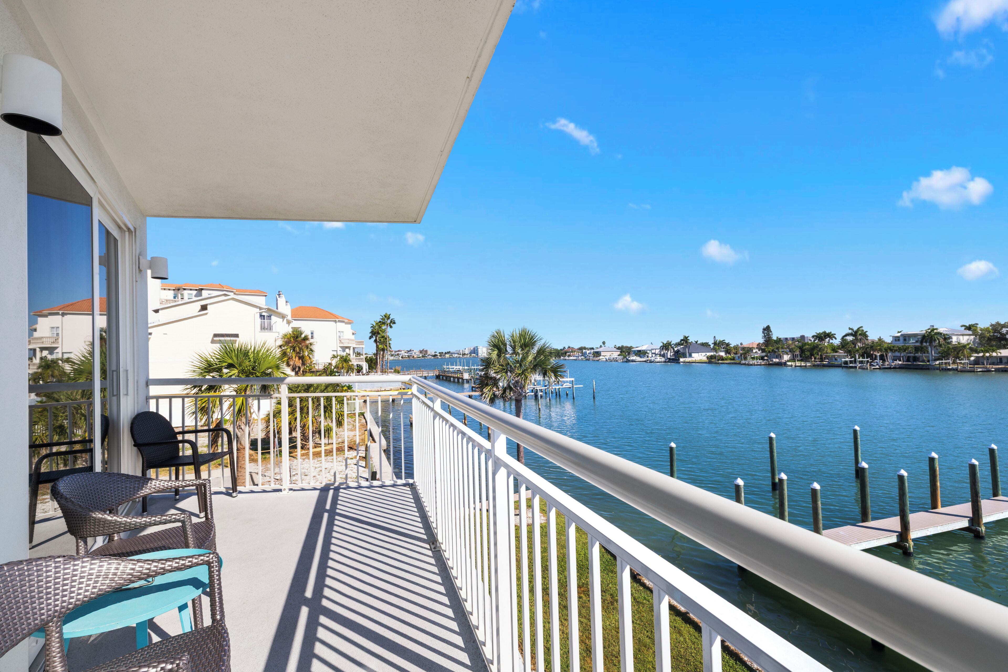 A balcony with outdoor furniture overlooking a marina and water.