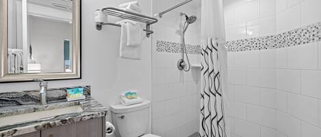 Un baño moderno con inodoro, lavamanos y ducha.