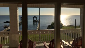 Un balcón con vista al mar, una terraza de madera y un pabellón.