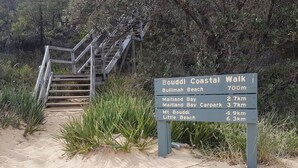 A directional sign at a beach with a wooden staircase leading up. - Amberlyn Escapes Killcare (Killcare Heights)