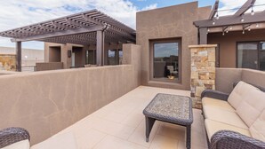 An outdoor patio with a pergola, a stone fireplace, and wicker furniture. - Poolside 3BR w/ Loft & 2 Kings on the 18th Green (St. George)
