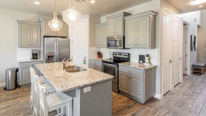 A modern kitchen with granite countertops, stainless steel appliances, and pendant lighting. - Poolside 3BR w/ Loft & 2 Kings on the 18th Green (St. George)