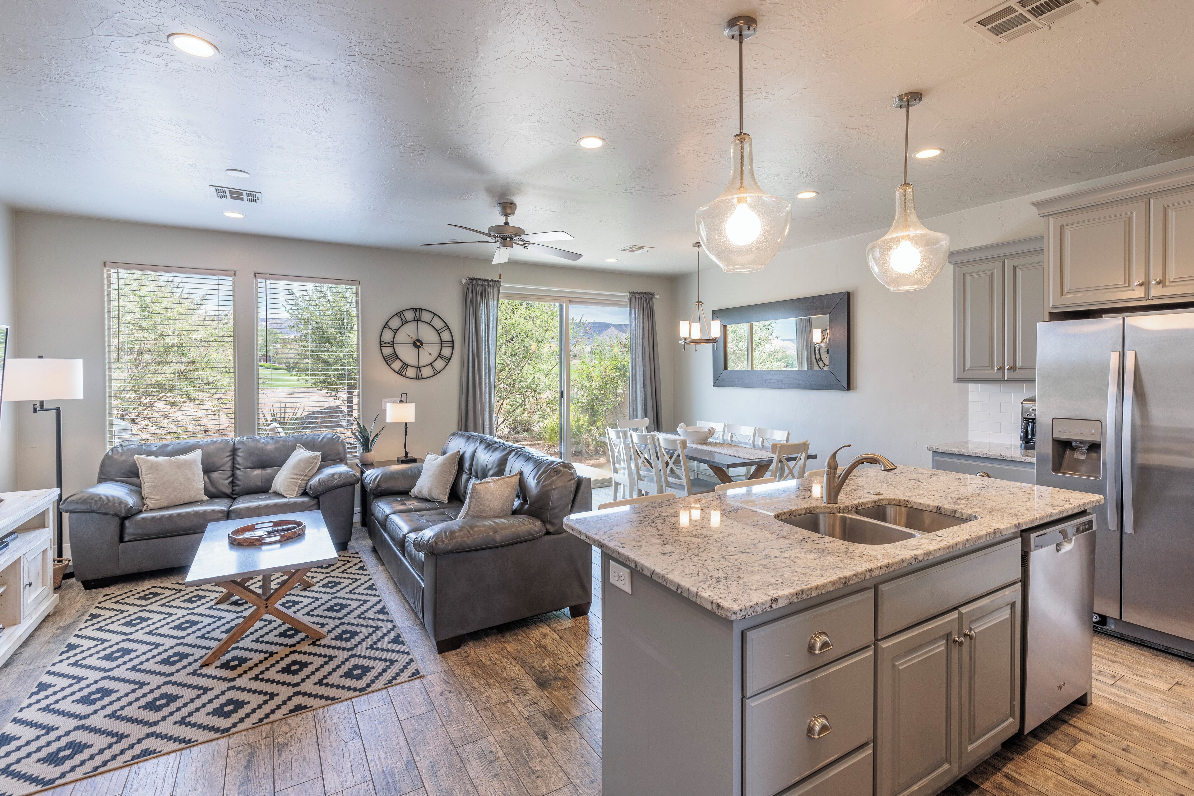 A modern kitchen with granite countertops, stainless steel appliances, and a dining area with a table and chairs.