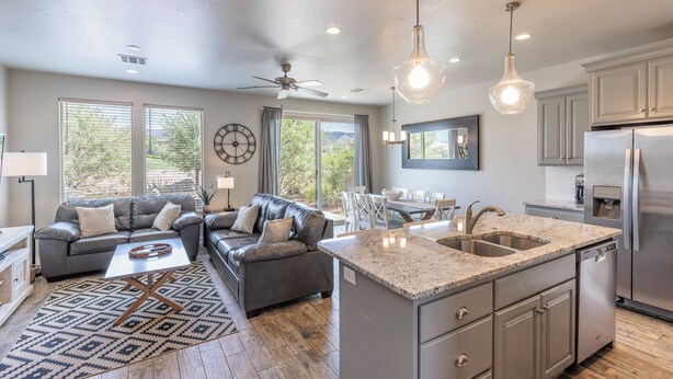 A modern kitchen with granite countertops, stainless steel appliances, and a dining area with a table and chairs. - Poolside 3BR w/ Loft & 2 Kings on the 18th Green (St. George)