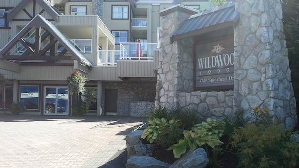 Un edificio con fachada de piedra y un letrero que dice "Wildwood Lodge".