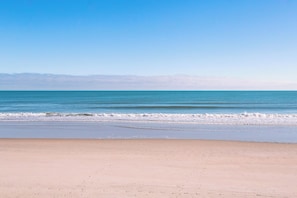 A beach with a clear sky and calm sea. - Shell Shocked - Oceanfront Surf Condo, Sleeps 6 (Surf City)