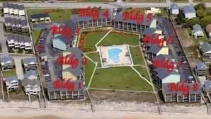 An aerial view of a coastal hotel complex with multiple buildings labeled from Bldg 1 to Bldg 8, featuring a central pool area and beachfront access. - Shell Shocked - Oceanfront Surf Condo, Sleeps 6 (Surf City)