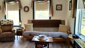Una sala acogedora con un sofá, un sillón y una mesita con un cuenco.