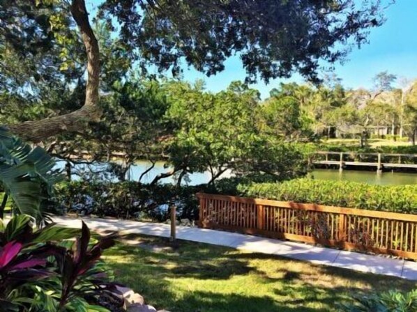 A tranquil outdoor area with a wooden fence, a pathway, and lush greenery.