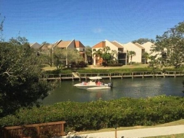 A waterfront property with a boat dock, a river, and a row of houses.