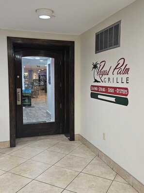 Un couloir mène à une porte qui donne sur un restaurant appelé « Royal Palm Grille », où l’on sert des fruits de mer, des steaks, des sushis et des huîtres.