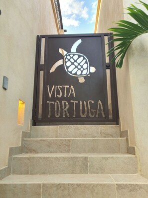 Ein Schild mit einer Schildkröte und dem Schriftzug 'Vista Turismo' an einer Treppe.
