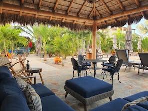 An outdoor seating area with wicker furniture and a thatched roof. - Vista Tortuga Ocean View VILLA-SUNSET Heated Pool by the BEACH (Todos Santos)