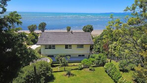 A house with a view of the sea, surrounded by greenery. - Maple's Den - Collingwood beach house (Collingwood)