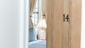 Ein Hotelzimmer mit Bett, Nachttisch und Lampe sowie einer Tür mit der Nummer 14.