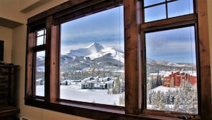 A room with large windows overlooking a snowy mountain landscape.