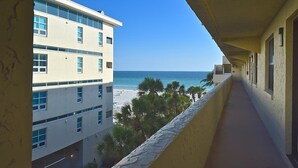 A corridor with a view of a beach and a building with multiple floors and windows. - Steps to Siesta Key Beach! Direct Access to Private Beach, Heated Pool. Sea Shell (Siesta Key)