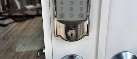 A door with a numeric keypad lock, a keyhole, and a lever handle.