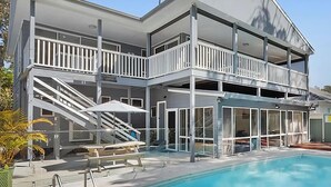 Ein zweistöckiges Gebäude mit Pool, Balkonen und einer überdachten Terrasse.