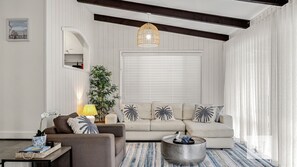 A living room with a sofa, armchairs, a coffee table, a lamp, and a hanging light fixture. - The Place - Pool, Lake, Kayaks & much more! (Gwandalan)