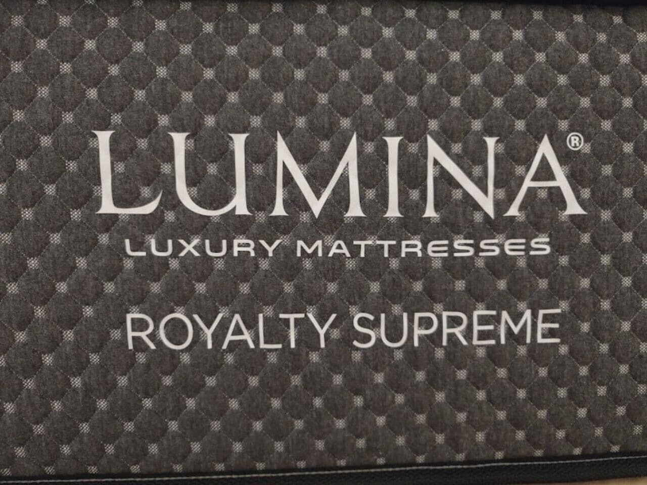 Une boîte sur laquelle est inscrit : « MATELAS DE LUXE LUMINA, GAMME ROYALE SUPRÊME ».