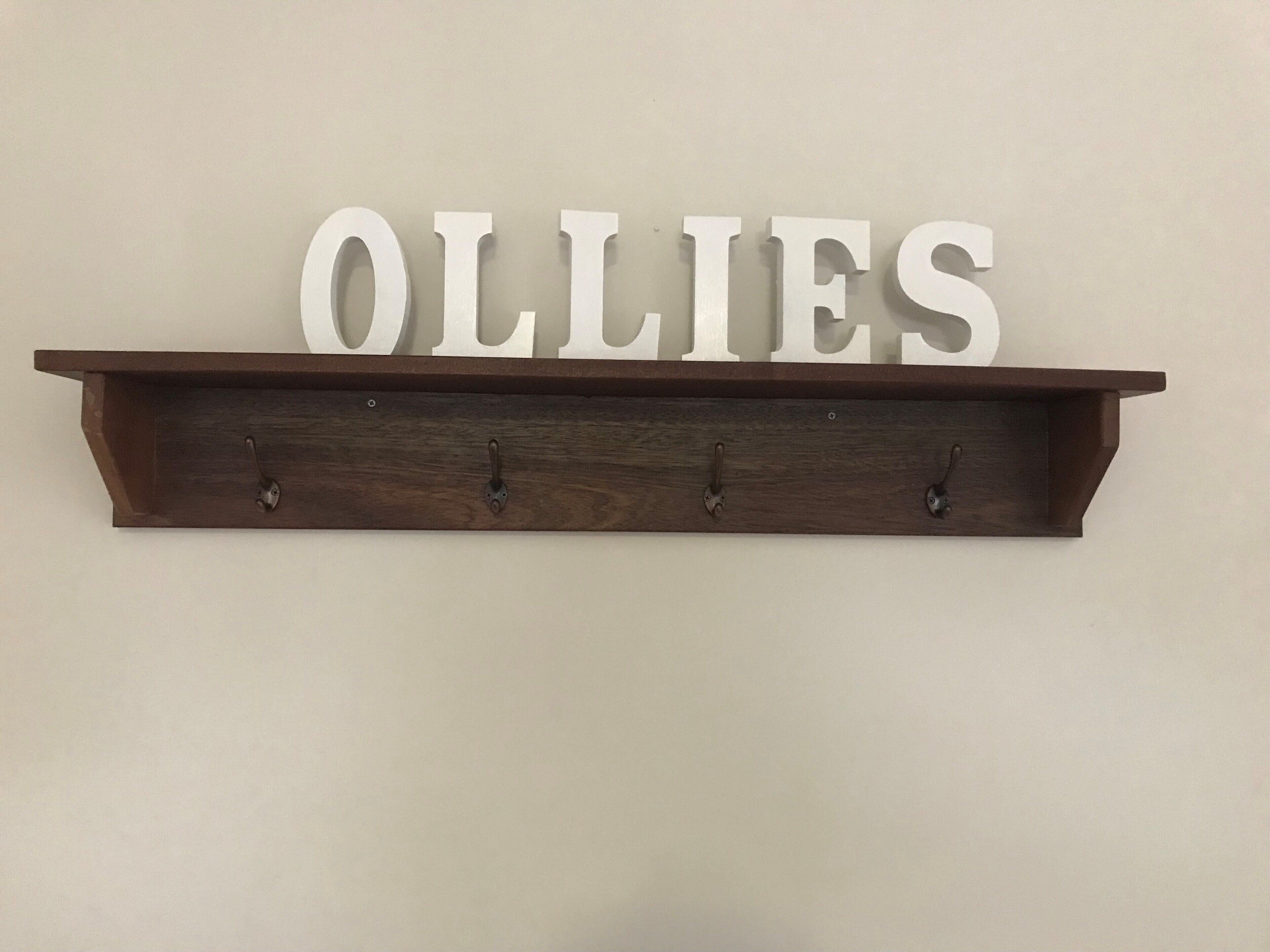 Estante de madeira com a palavra "OLLIES" fixada na parede.