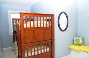 A room with a bunk bed, a round mirror, and a bench with a cushion. - Patient Tide Beautiful 3 BR Ocean View Home; Community Pool & Tennis Courts (North Topsail Beach)