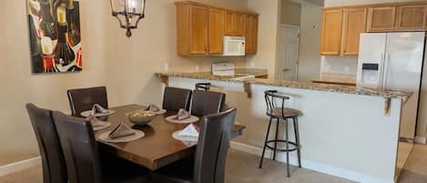 A kitchen with wooden cabinets, a microwave, and a refrigerator.