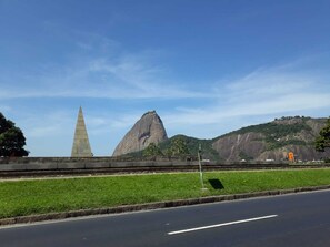 A road with a grassy median and a monument on the left. - In front of the sea! Enjoy Rio with Tranquility, Comfort and many Facilities!!! (Rio de Janeiro)
