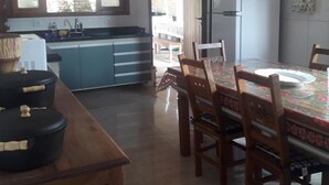 Una cocina amplia con comedor, que incluye una isla grande, sillas de madera y un refrigerador.