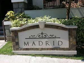 Set against lush greenery, the MADRID sign stands proudly atop a stone structure.