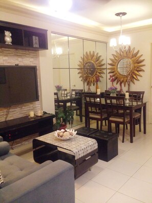 Relax in a stylish living room with a flat-screen TV, comfortable sofa, and dining area.