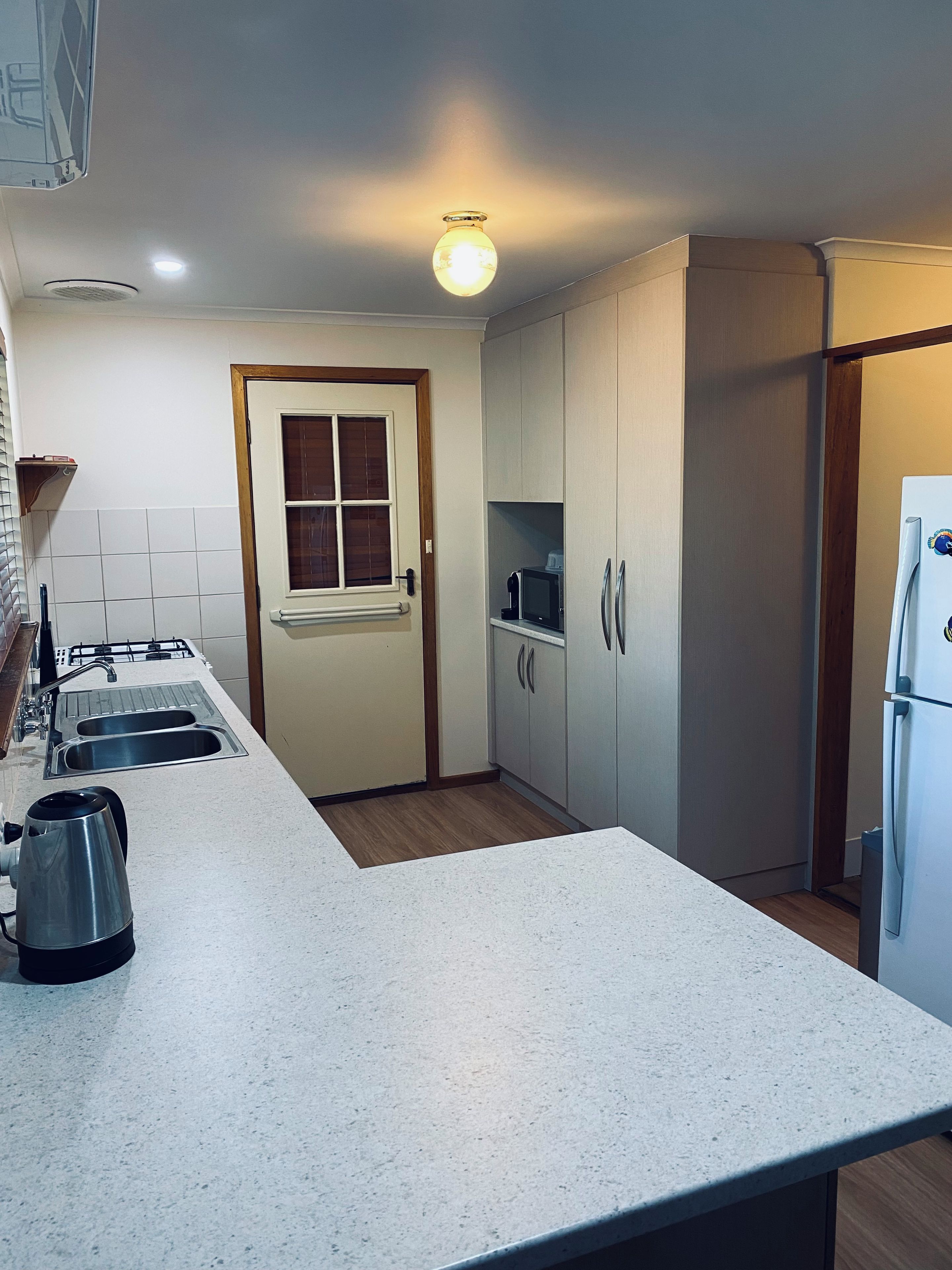 A kitchen with a countertop, sink, stove, and cabinets.